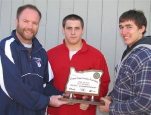 Kevin Moffatt, athletic director, Nick Theimer, Derek Barth, team captains; display the Oregon State Athletic Association second-place trophy in the 2A division.