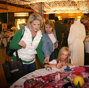 Women at a previous Ladies Night Out shop and sign up for prize drawings.