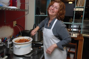In her kitchen at Rolling Hills Bakery and Cafe, Molly Ainsley stirs the chili she’s made from her new product, SortaSausage, which can substitute for ground beef or pork in many recipes.     