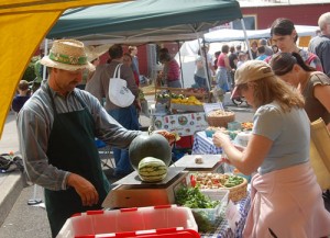 Bill Schiedler of Gardenripe Farm handles a melon purchase at last year\'s Silverton Farmers\' Market.