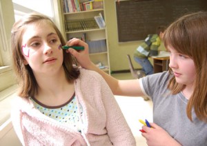 Butte Creek Elementary student Jasmine Hill practices using face paint on Mariah Kimlinger before the school’s inugural Giving Fair on May 27 at the school. Proceeds benefit Mano Amiga, an organization helping homeless, orphaned and abused children in Ecuador.