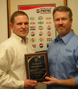 Pepsi plant manager Al Fiedler and Pepsi operations manager Jason Ward hold the award from the Mount Angel Chamber of Commerce.