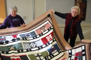 Adelene Hammelman helps Margaret Gersch display the Hobo quilt she made to show at The Oregon Garden’s Quilt Show.