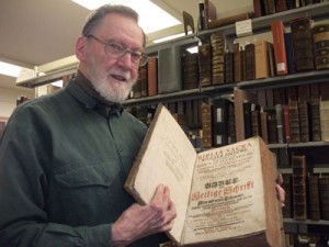 Josef Sprug displays a 16th century Bible from the library’s collection.