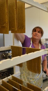 Pati Harris hangs sheets of pasta to dry.