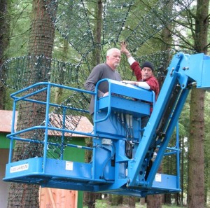 Workers hanging decorations in the Discovery Forest for Christmas in the Garden.