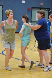 Bev Fleckenstein demonstrates the maypole steps while Nann Fleck guides a young dancer into a turn. 