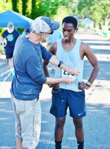 JFK cross country and track coach Steve Ritchie congratulates Haile Stutzman, 16, for winning the men’s 5K race.