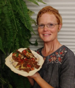 Elizabeth Voth displaying tacos made from her blue corn tortillas