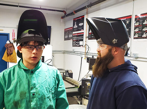 Kennedy senior welding student Oscar Gonzalez with teacher Alex Snegirev in the welding room.
