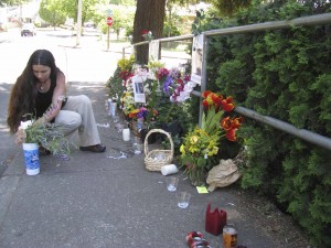 Melanie Heise arranges the flowers at her brother’s memorial on Oak Street.  She said she and her brother, AJ, were “peas in a pod.”