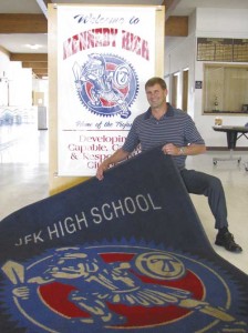 JFK High School Principal Troy Stoops rolls out the carpet to welcome students back to school.