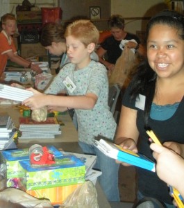 Volunteers with the Apple Tree School Supplies program sort tablets, pens, markers and other items donated.  