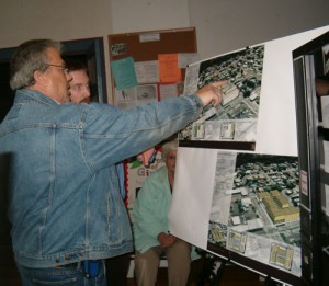 Meeting participants take a look at potential lay-outs for a building to house senior citizens and retail or office space on land now occupied by Potter\'s Automotive.