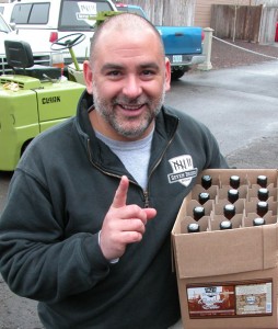 Jeff DeSantis, one of five partners at Seven Brides Brewing in Silverton, holds the first case of beer off the mobile bottling line.