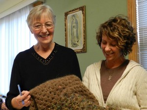 Sister Dorothy Jean and Barbara Beyer examine a shawl.