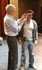 Director Don Kelley works with the mic system for performer Joe Huang.