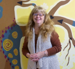 Carole DeMar in front of the Old Oak mural at Talking Oak Studios.   Melissa Wagoner