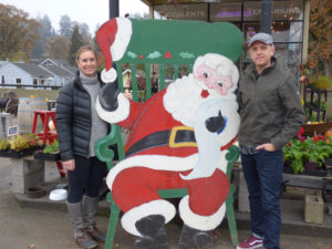 Heather Desmarteau-Fast and Courtney Fast, owners of the Coffee Station and Stamen and Pistil with the vintage Santa from the old 76 Station.       Melissa Wagoner