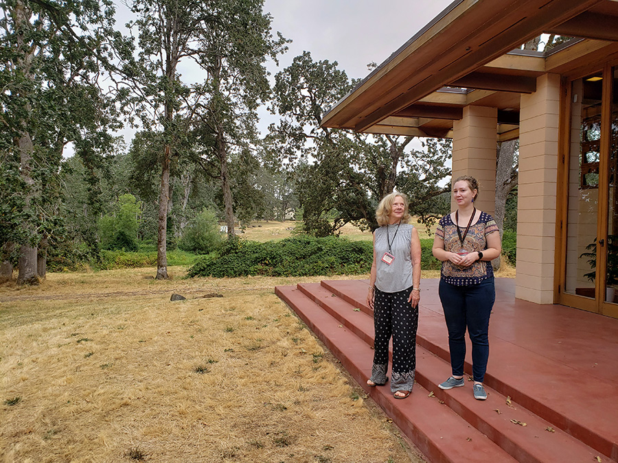 Kathy Stemmler, left, and Mairee McInnes on the steps of the Gordon House leading from the expansive living room windows to the outside.  A grant from the Oregon Cultural Trust will help the complete a landscaping plan.     