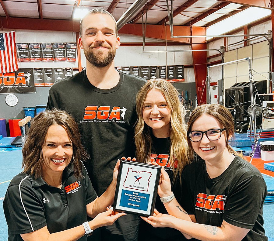 Silverton Gymnastics Academy coaches, from left, Celia Storey, Andrew Barry, Justice Storey  and Morgan Smith are shown with the state award they received from USA Gymnastics.  