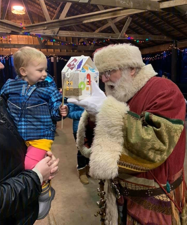 Santa interacting with a Children's Lantern Parade participant.