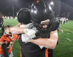 Foxes WR Vandon Fessler hugs his father, assistant coach Mike Fessler, after Vandon’s pass reception clinched a 26-20 Silverton win vs. Thurston in the 2021 Class 5A state title game in Hillsboro.   James Day