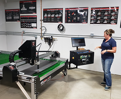 Korrie Shull, the Kennedy High welding teacher, works with the new welding room’s plasma cutter, which was paid for with a grant from the Marion County Board of Supervisors.  James Day