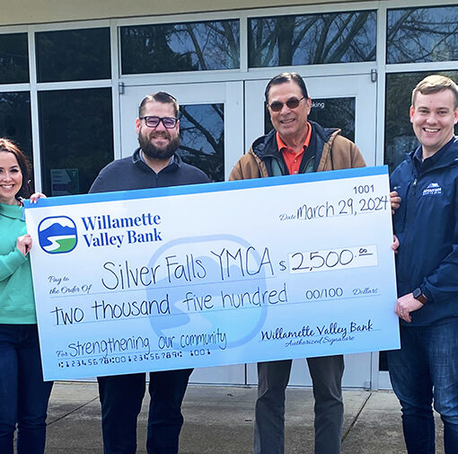 Willamette Valley Bank community engagement officer Daylee Howard, left, and branch manager Joshua Keck present Silver Fallsy Family YMCA board president Chuck White and board member Bryan White with a check for $2,500. Submitted photo