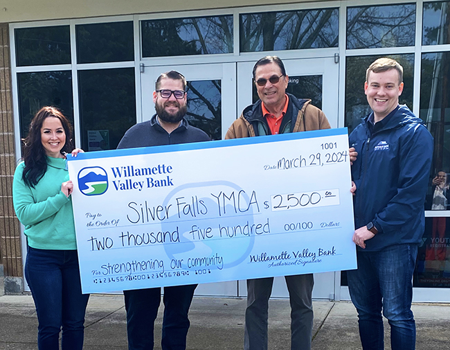Willamette Valley Bank community engagement officer Daylee Howard, left, and branch manager Joshua Keck present Silver Fallsy Family YMCA board president Chuck White and board member Bryan White with a check for $2,500. Submitted photo