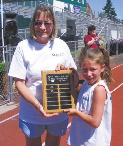 Peggy Wilson, left, displays the award naming Stayton Cooperative Telephone the top money raising team for the 2008 Relay for Life.	